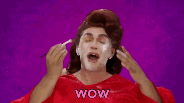 a woman in a red dress is applying makeup to her face and the word wow is on the purple background .