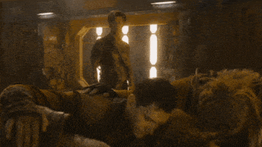 a man is laying on another man 's chest in a room