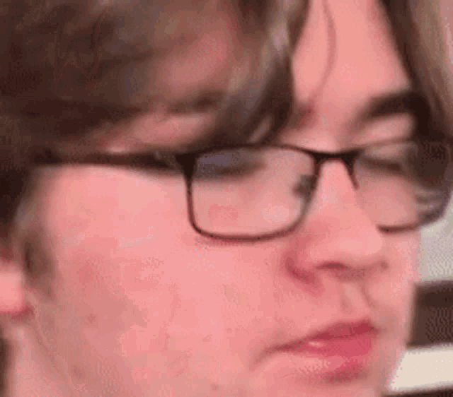 a close up of a young man wearing glasses .