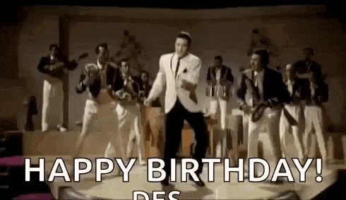 elvis presley is dancing on a stage in front of a band while singing happy birthday .