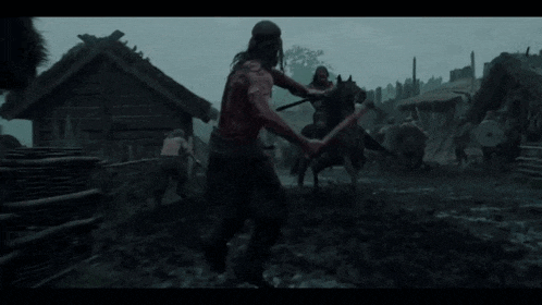 a man with a sword is fighting another man with a sword in a field .