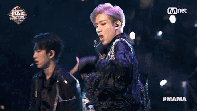 a man singing into a microphone at a music awards