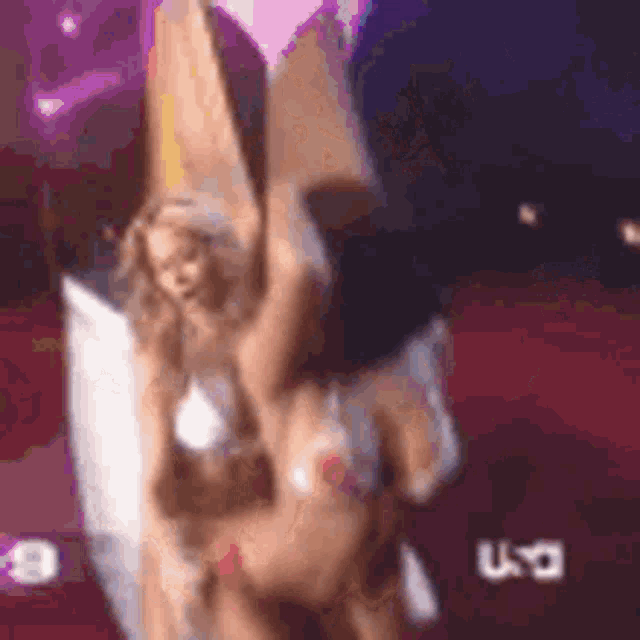 two women in bikinis are dancing on a stage in front of a tv screen that says u.s.