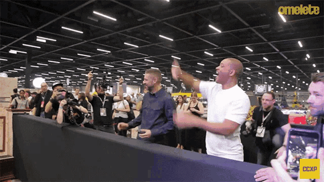 two men are standing in front of a crowd with the word amelete on the bottom