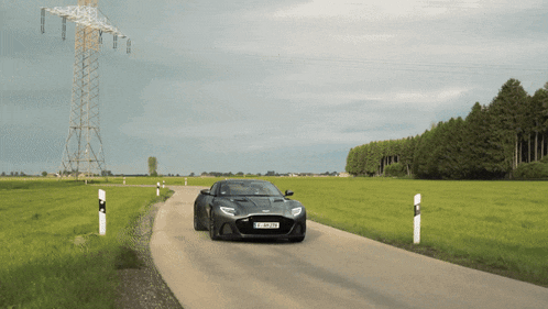 a black sports car with a license plate that says lp-bp179 is driving down a country road
