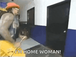 a man in a hat is standing in a hallway holding a hose and saying `` i 'm home woman ''