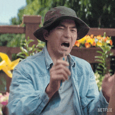 a man wearing a hat and a denim shirt has a netflix logo on the bottom