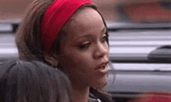 a woman wearing a red headband and earrings is talking to another woman .
