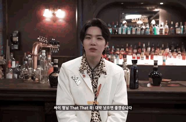 a man standing in front of a bar with bottles of alcohol and a sign that says saloon