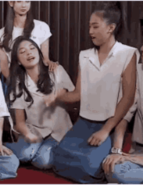a group of young women are sitting on the floor with their legs crossed .