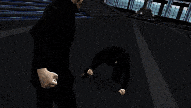 a man in a suit is being kicked in the face by another man in a suit