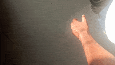 a man 's hand is reaching out towards a light