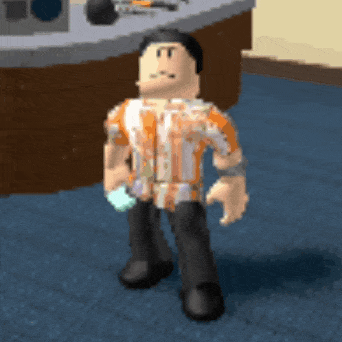 a man in an orange shirt and black pants is standing on a blue floor .