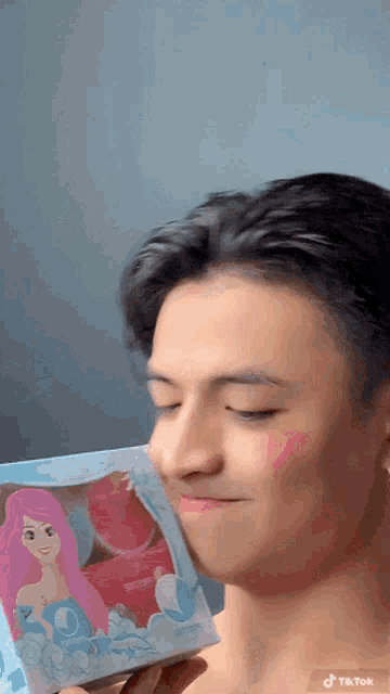 a man is holding a box with a mermaid on it