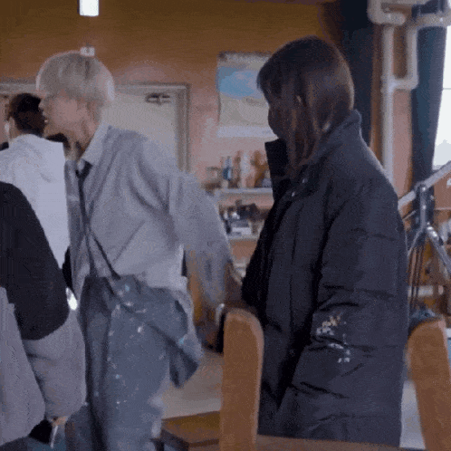 a man and a woman are standing next to each other in a room with a map on the wall behind them