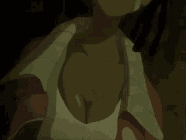a close up of a woman 's breasts in a white shirt .