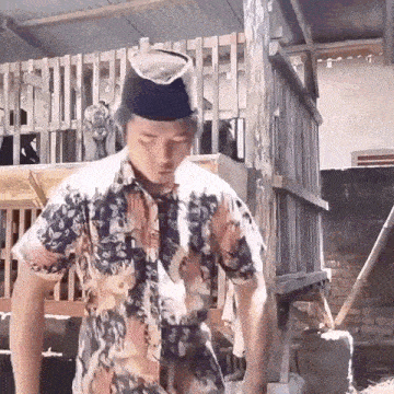 a man wearing a hat and a floral shirt