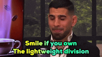 a man says smile if you own the lightweight division while holding a cup of coffee