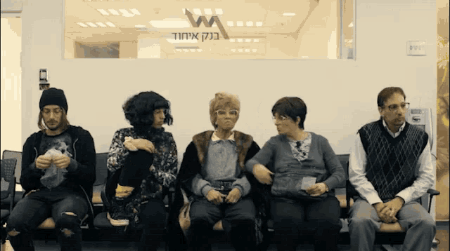 a group of people sitting in a waiting room with a sign that says w
