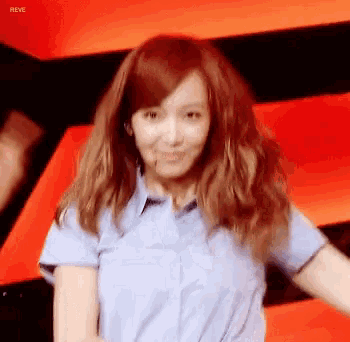 a woman with red hair is wearing a blue shirt and the word reve is on the bottom right