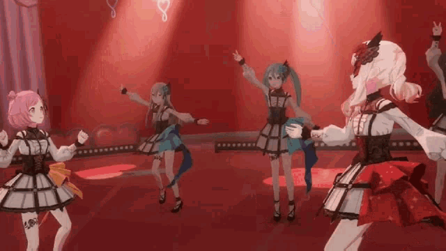 a group of anime girls are dancing on a stage in front of a red background .