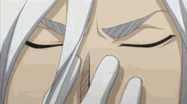 a person with long white hair is covering their face with their hands .