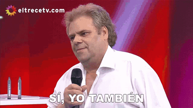 a man speaking into a microphone with the words si yo tambien below him