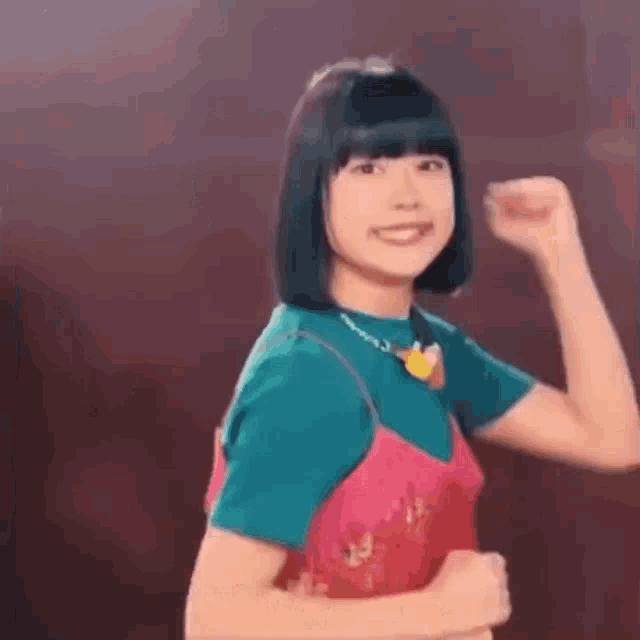a young woman is flexing her muscles and smiling .