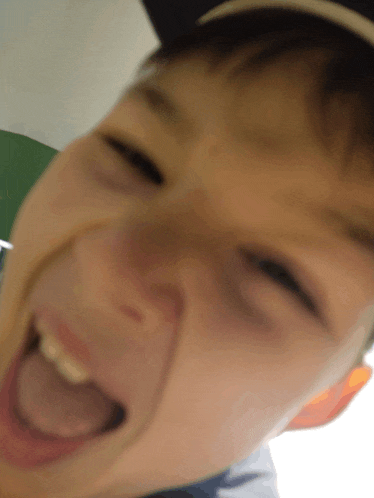 a close up of a child 's face with his mouth open