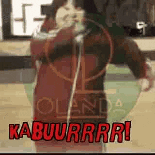 a person is singing into a microphone on a basketball court while holding a hoop .