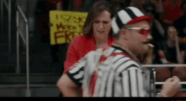 a referee stands in front of a woman holding a sign that says i love beef