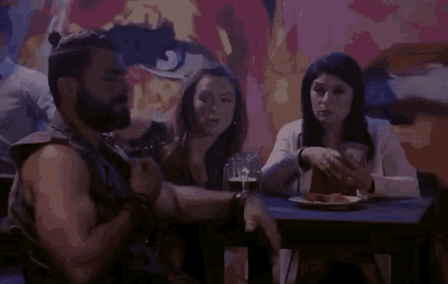 a man with a beard sits at a table with a woman