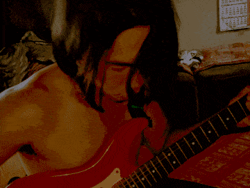 a picture of a man playing a guitar with a calendar behind him
