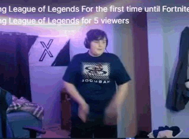 a boy wearing headphones and a league of legends shirt is dancing in a room with purple lights .