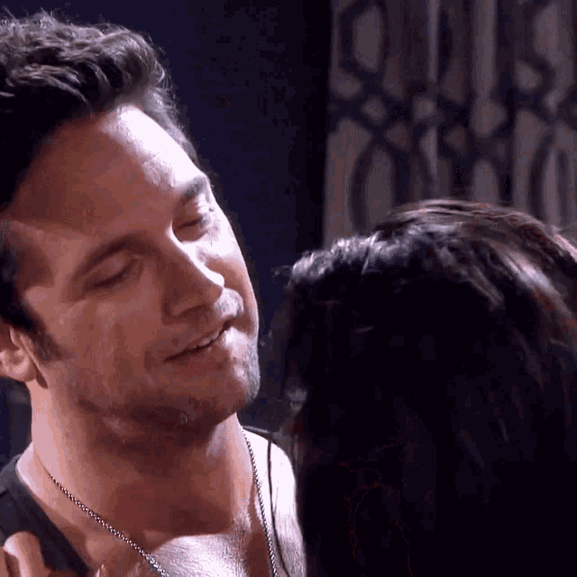 a man and a woman are looking at each other and smiling