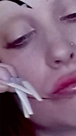 a close up of a woman 's face with a nose piercing