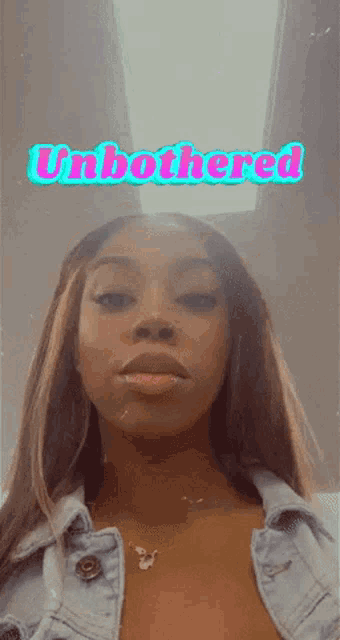 a woman in a denim jacket with the words " unbothered " on the bottom
