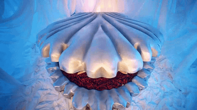 a sculpture of a sea shell with a red velvet cake inside of it