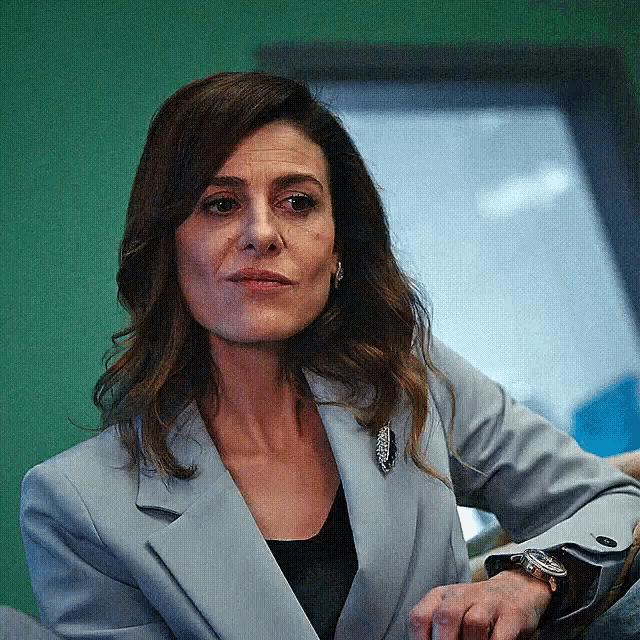 a woman wearing a grey jacket and a watch