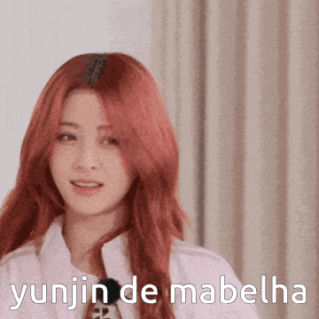 a woman with red hair and the words yunjin de mabelha behind her