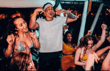 a group of people are dancing in a club and one of them is wearing a bikini top
