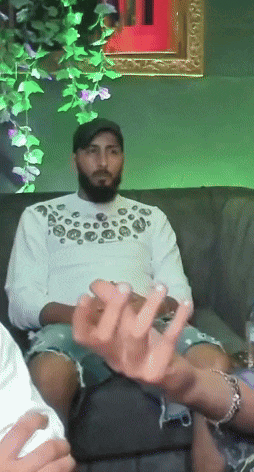 a man with a beard is sitting on a couch