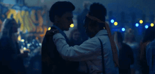 a man and a woman are dancing in front of a sign that says bonus