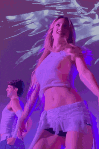 a woman singing into a microphone with a purple background