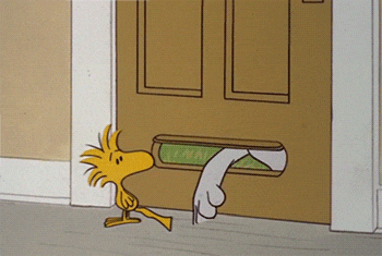 a cartoon drawing of woodstock standing next to a mailbox