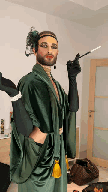 a man in a green robe is holding a cigarette holder