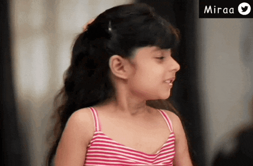 a little girl wearing a pink and white striped tank top is smiling