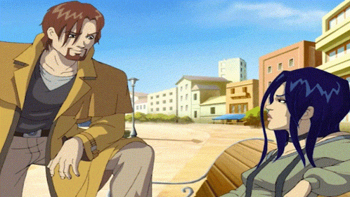 a man and a woman are sitting on a bench in a city
