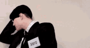 a man in a suit and tie with a name tag that says xerox is dancing .