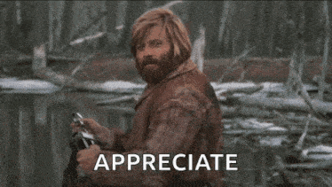 a man with a beard is smiling and the word appreciate is on the screen behind him